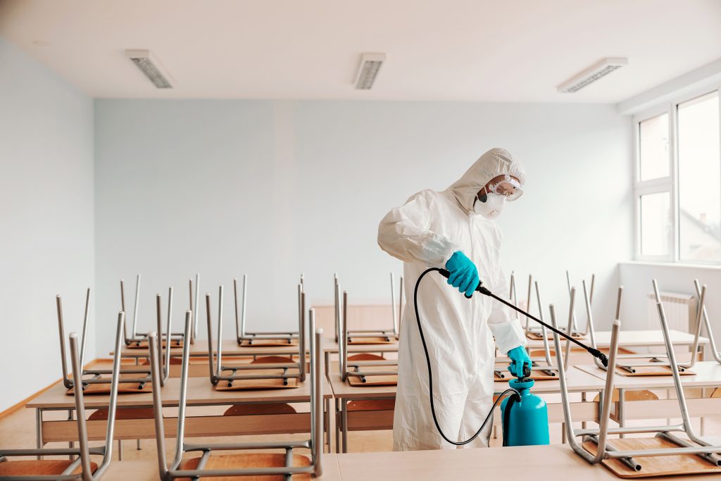 operatore sanitario che sanifica scuola con prodotti disinfettanti della Newpharm